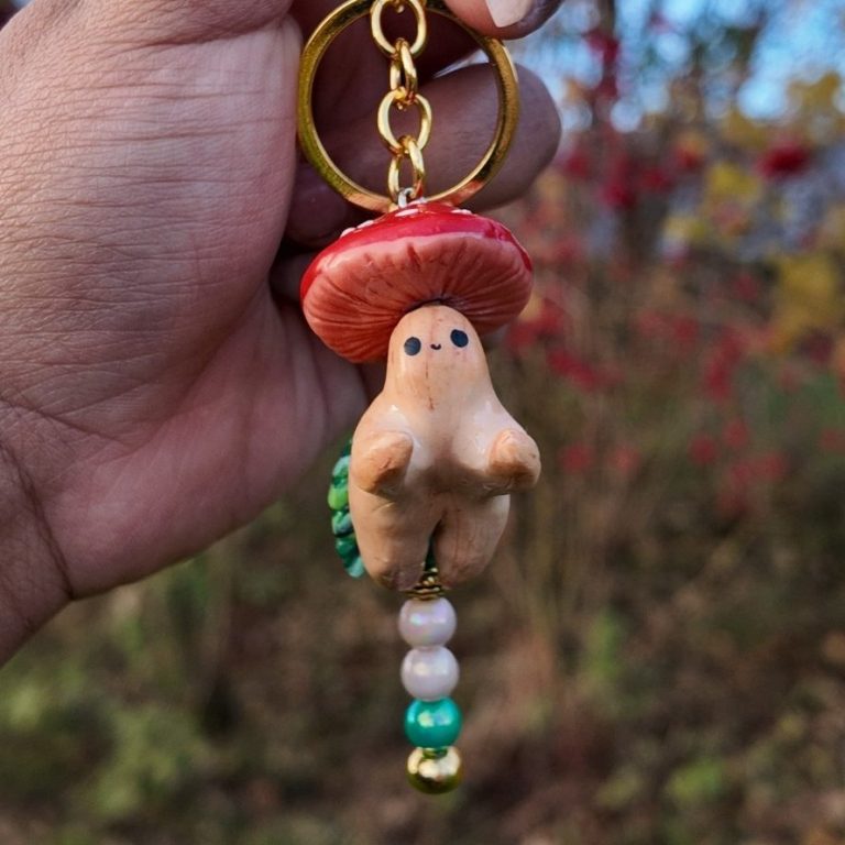 Forest Buddy Anhänger Handschlüsselanhänger in Form eines Pilzes mit rotem Hut und bunten Perlen.